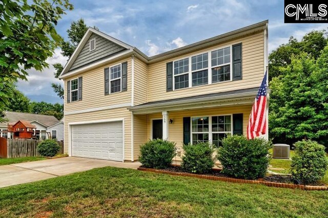 front facade with a garage, a front yard, and central AC