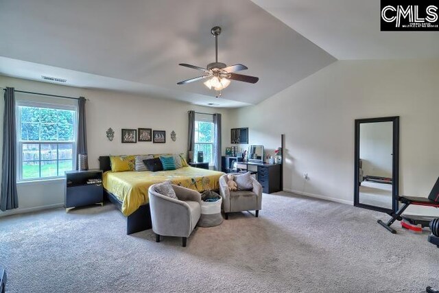 carpeted bedroom with ceiling fan, multiple windows, and vaulted ceiling