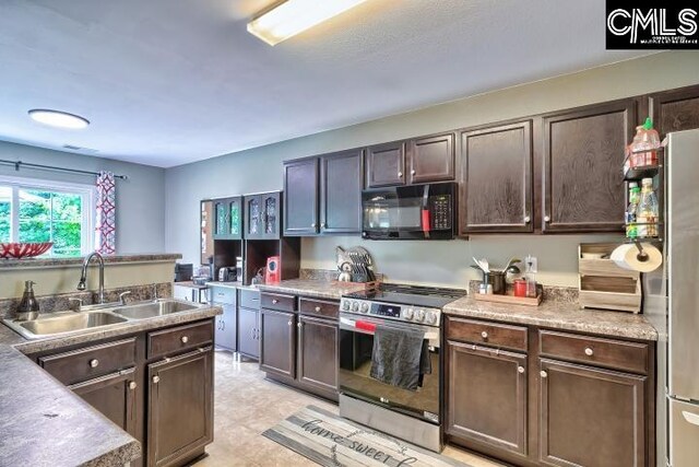 kitchen with sink, dark brown cabinets, light tile patterned floors, and stainless steel appliances