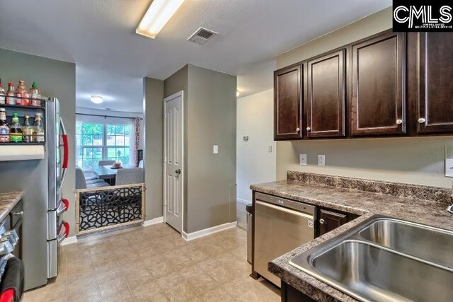 kitchen with dark brown cabinetry, stainless steel dishwasher, and sink