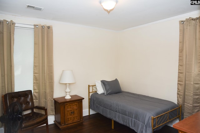 bedroom featuring ornamental molding and dark wood-type flooring