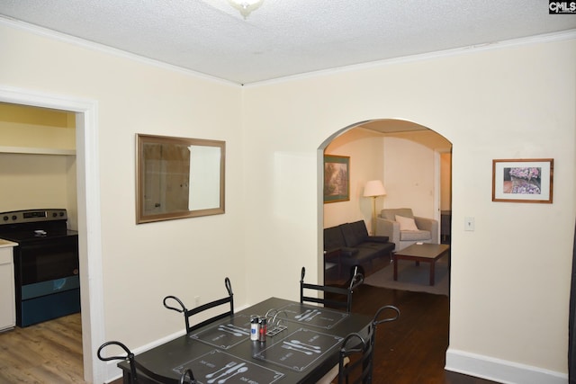 dining space with a textured ceiling, dark wood-type flooring, and crown molding