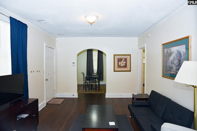 living room featuring a textured ceiling, dark hardwood / wood-style floors, and crown molding