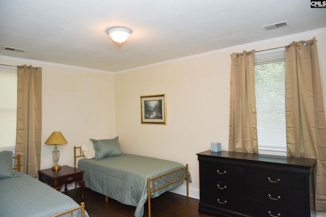 bedroom with crown molding and dark hardwood / wood-style flooring