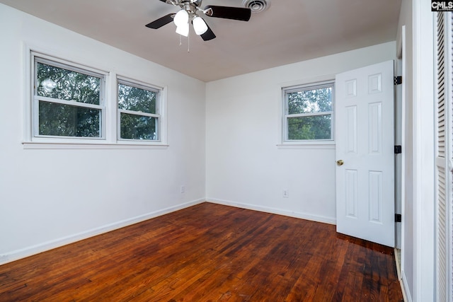 spare room with dark hardwood / wood-style flooring and ceiling fan