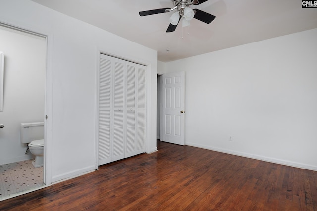 unfurnished bedroom featuring ceiling fan, a closet, dark hardwood / wood-style floors, and ensuite bathroom