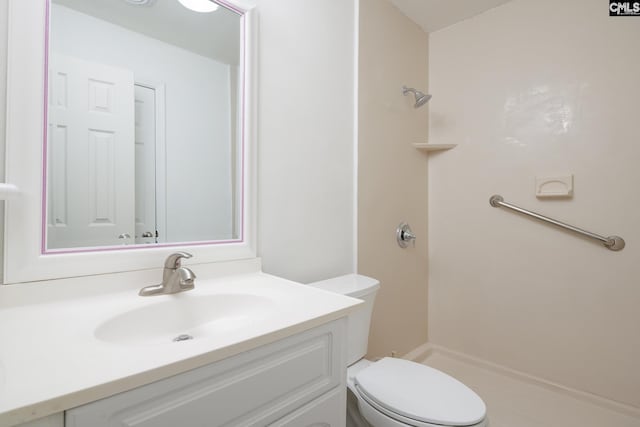 bathroom with vanity, a shower, and toilet