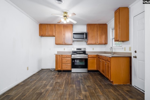 kitchen with appliances with stainless steel finishes, crown molding, dark hardwood / wood-style flooring, and ceiling fan