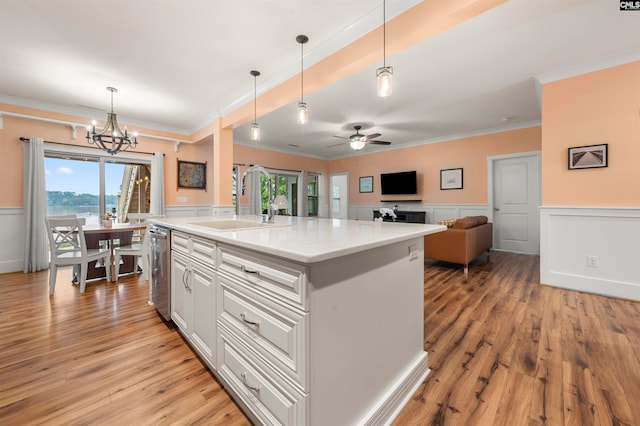 kitchen with an island with sink, pendant lighting, and light wood-type flooring