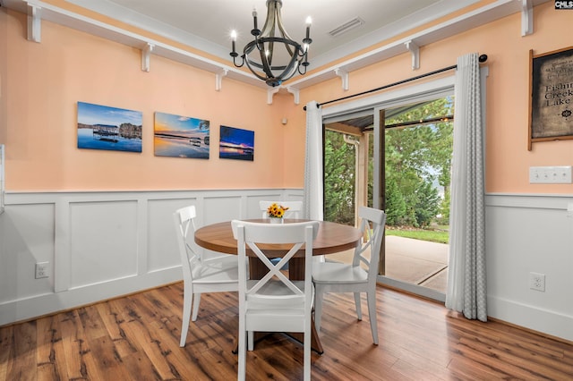 dining space featuring wood-type flooring and a notable chandelier