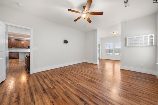 unfurnished living room with dark wood-type flooring and ceiling fan