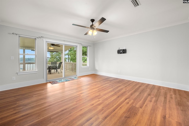 empty room featuring hardwood / wood-style flooring, crown molding, and ceiling fan