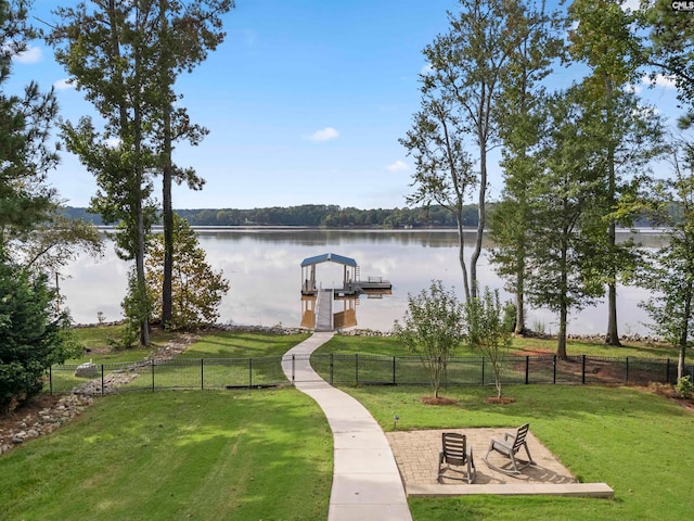 view of community with a water view, a dock, and a lawn