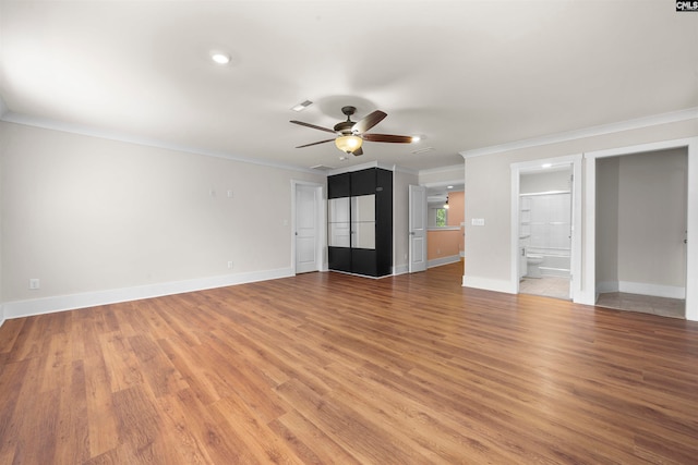 interior space with wood-type flooring, connected bathroom, crown molding, and ceiling fan