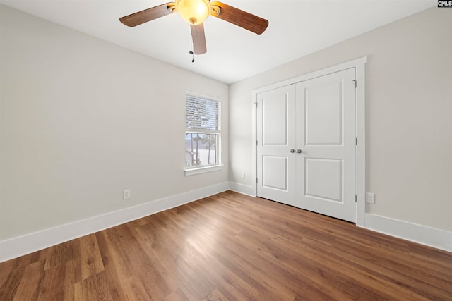 unfurnished bedroom with ceiling fan, a closet, and hardwood / wood-style floors