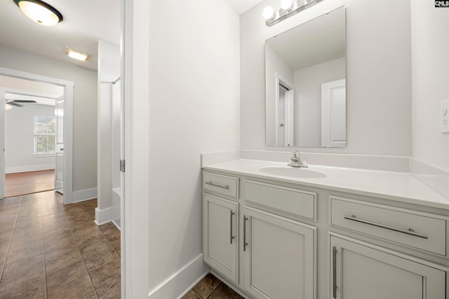 bathroom featuring tile patterned floors, ceiling fan, a washtub, and vanity