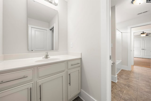 bathroom featuring  shower combination, vanity, and ceiling fan