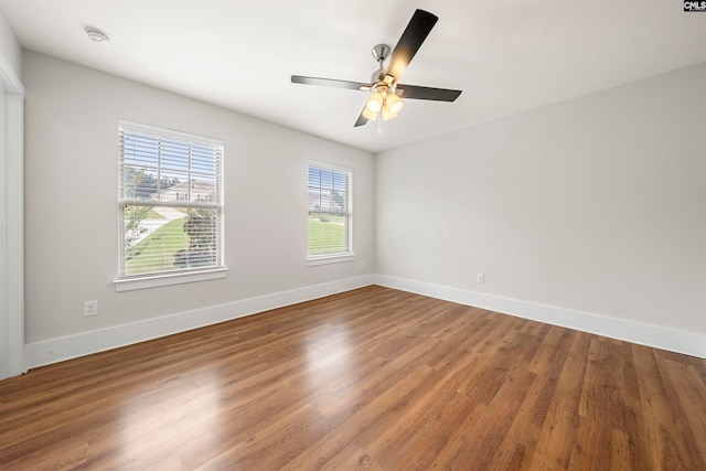 empty room featuring wood-type flooring, ceiling fan, and a wealth of natural light