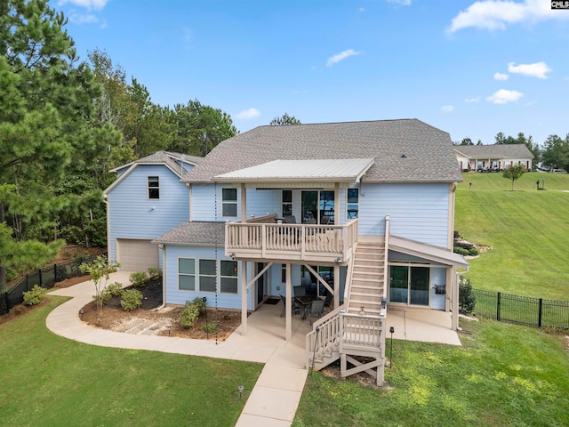 back of property featuring a deck, a lawn, and a patio