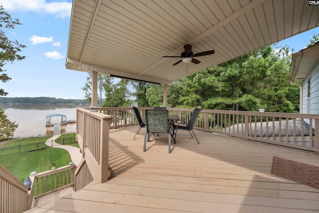 deck with a water view and ceiling fan