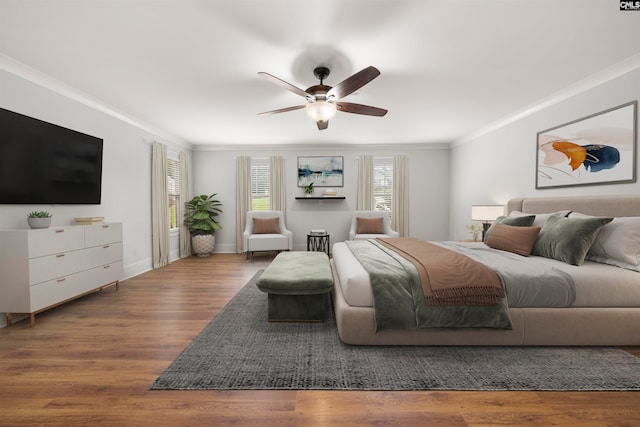 bedroom featuring wood-type flooring, ornamental molding, and ceiling fan