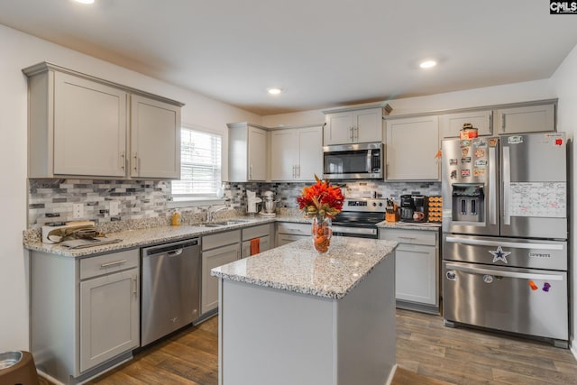 kitchen featuring gray cabinetry, a center island, appliances with stainless steel finishes, and dark hardwood / wood-style flooring