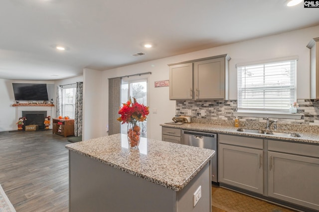 kitchen with a wealth of natural light, a center island, dark hardwood / wood-style floors, and sink