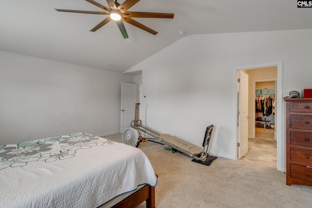 carpeted bedroom with ceiling fan, lofted ceiling, a closet, and a walk in closet