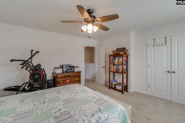 carpeted bedroom with ceiling fan and a closet