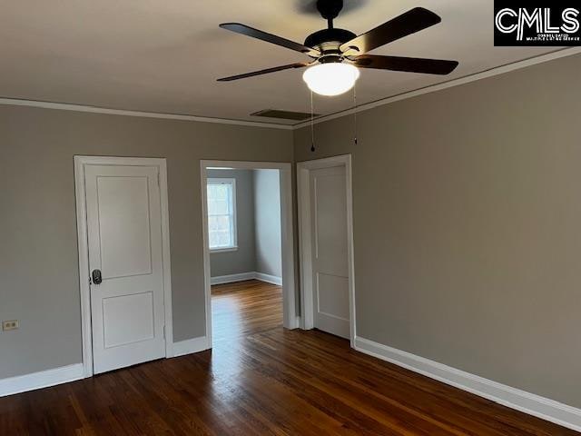 spare room with ceiling fan, ornamental molding, and dark hardwood / wood-style flooring