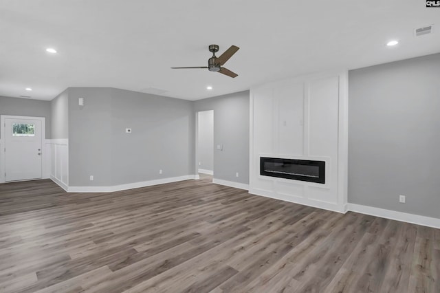 unfurnished living room with wood-type flooring and ceiling fan