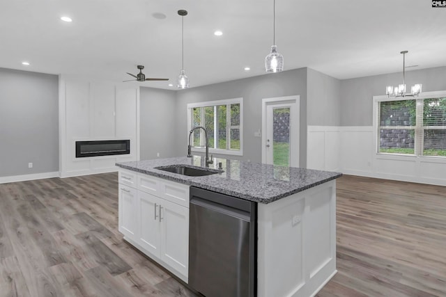 kitchen featuring sink, stainless steel dishwasher, a kitchen island with sink, white cabinetry, and light wood-type flooring