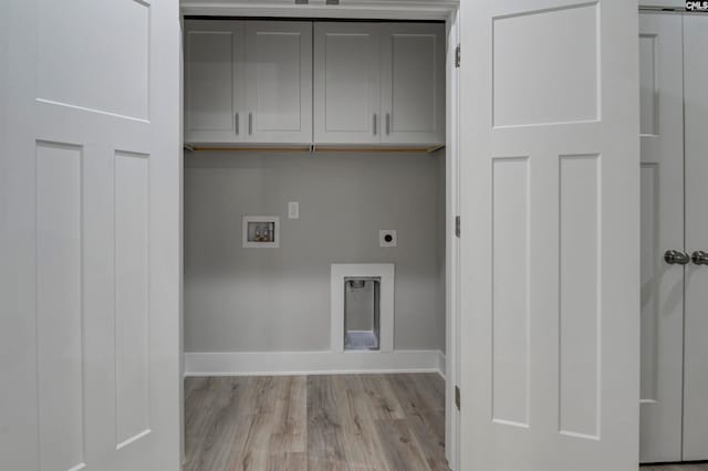 laundry area featuring light wood-type flooring, hookup for a washing machine, electric dryer hookup, and cabinets