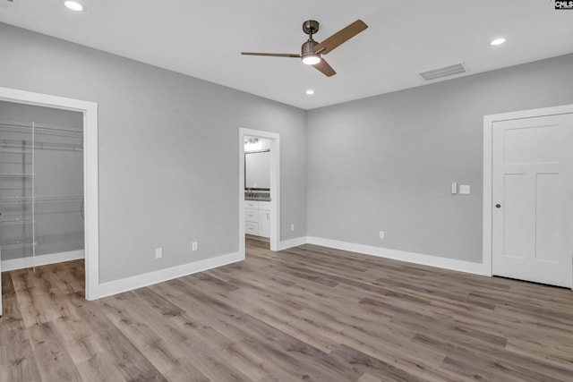 unfurnished bedroom featuring light wood-type flooring, ceiling fan, and a closet