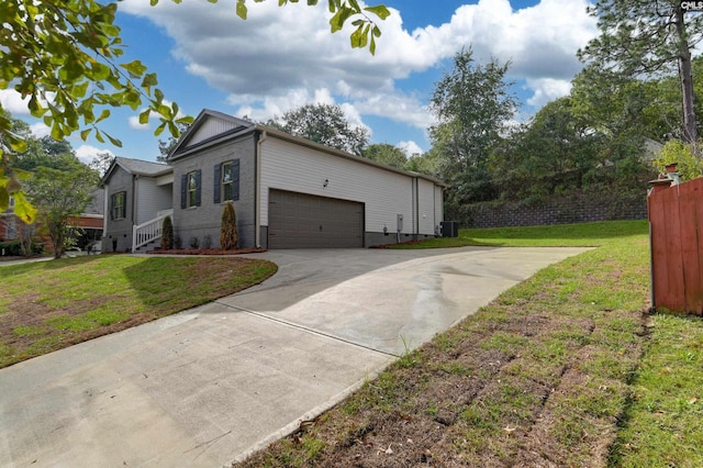 view of side of home featuring a garage, central AC unit, and a yard