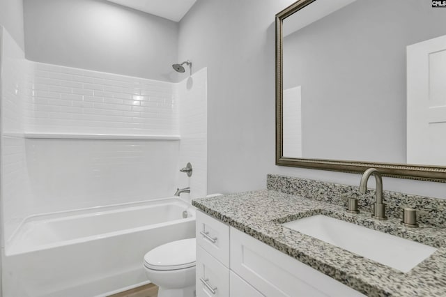 full bathroom with tiled shower / bath, vanity, and toilet