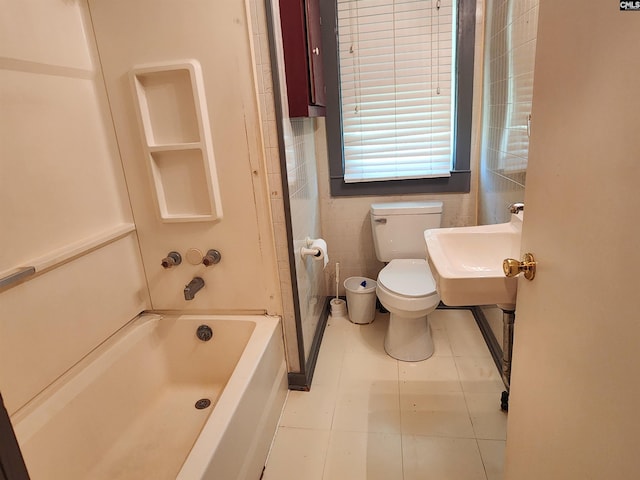 bathroom with shower / washtub combination, tile walls, tile patterned flooring, and toilet