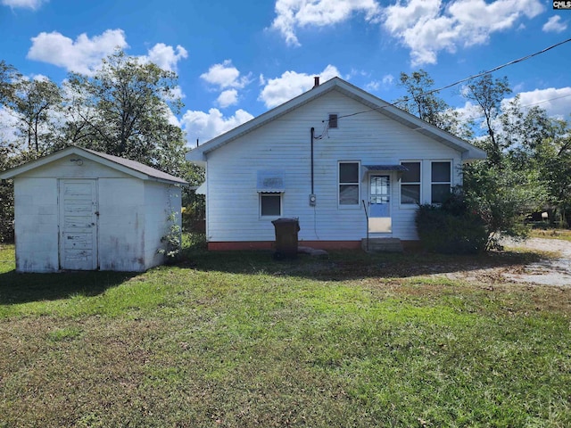 back of property featuring a yard and a storage unit