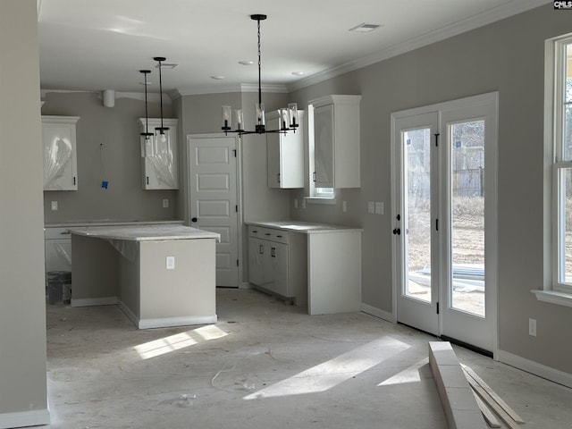 kitchen with baseboards, a kitchen island, visible vents, and white cabinetry