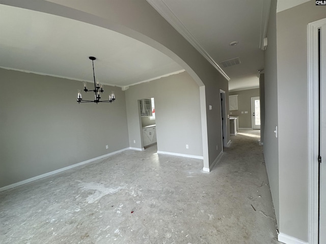 spare room with baseboards, visible vents, arched walkways, crown molding, and a chandelier