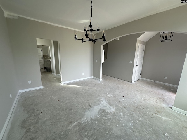 unfurnished dining area with a chandelier, arched walkways, and baseboards