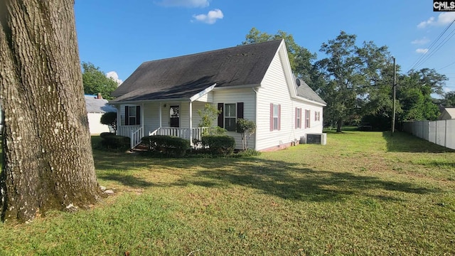 view of front of property with central AC, a front yard, and a porch