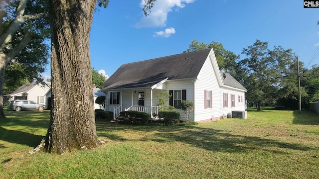 view of side of home with central AC, covered porch, and a yard