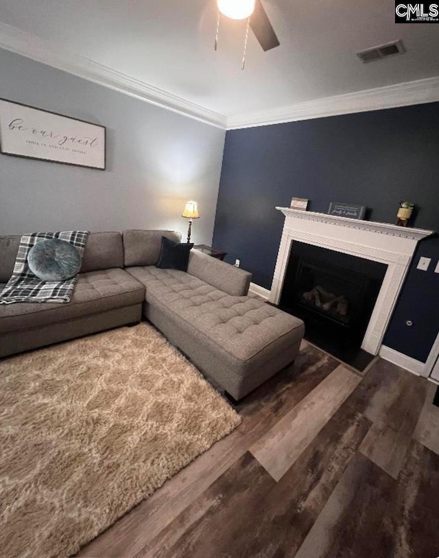 living room featuring hardwood / wood-style flooring, ceiling fan, and ornamental molding