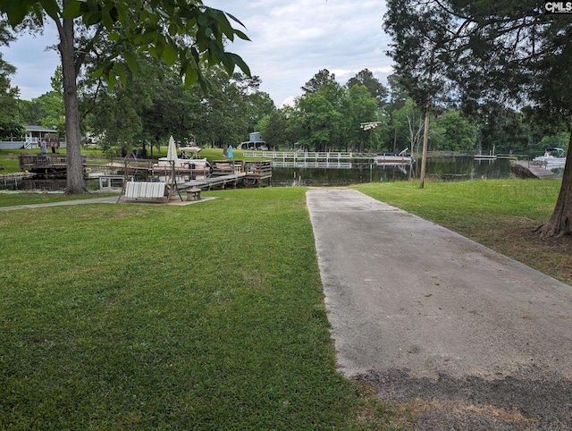 view of community with a lawn and a water view