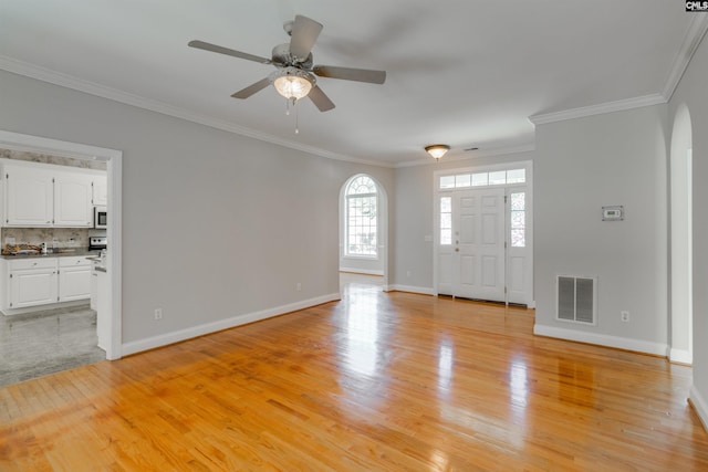 entrance foyer featuring ceiling fan, ornamental molding, and light hardwood / wood-style floors