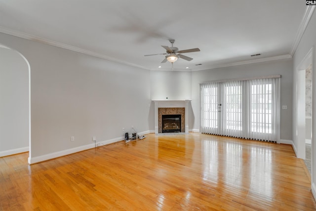 unfurnished living room with a fireplace, crown molding, wood-type flooring, and ceiling fan