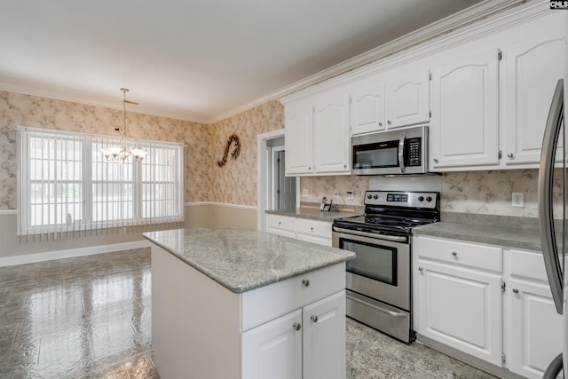 kitchen with white cabinetry, an inviting chandelier, appliances with stainless steel finishes, a kitchen island, and pendant lighting