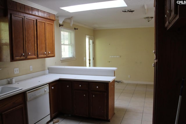 kitchen featuring a skylight, ornamental molding, kitchen peninsula, light tile patterned floors, and dishwasher