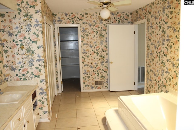 bathroom featuring tile patterned floors, ceiling fan, a washtub, and vanity